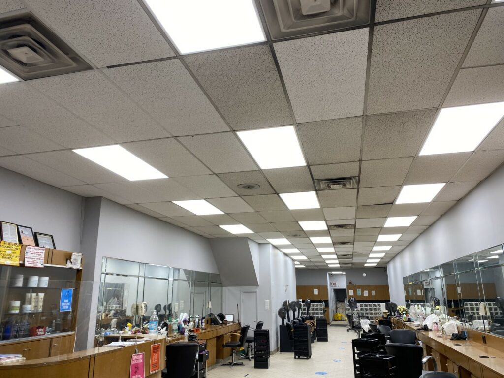 Brightly lit salon interior with ceiling lights, mirrors, and styling stations, expertly serviced by ORBA Electric